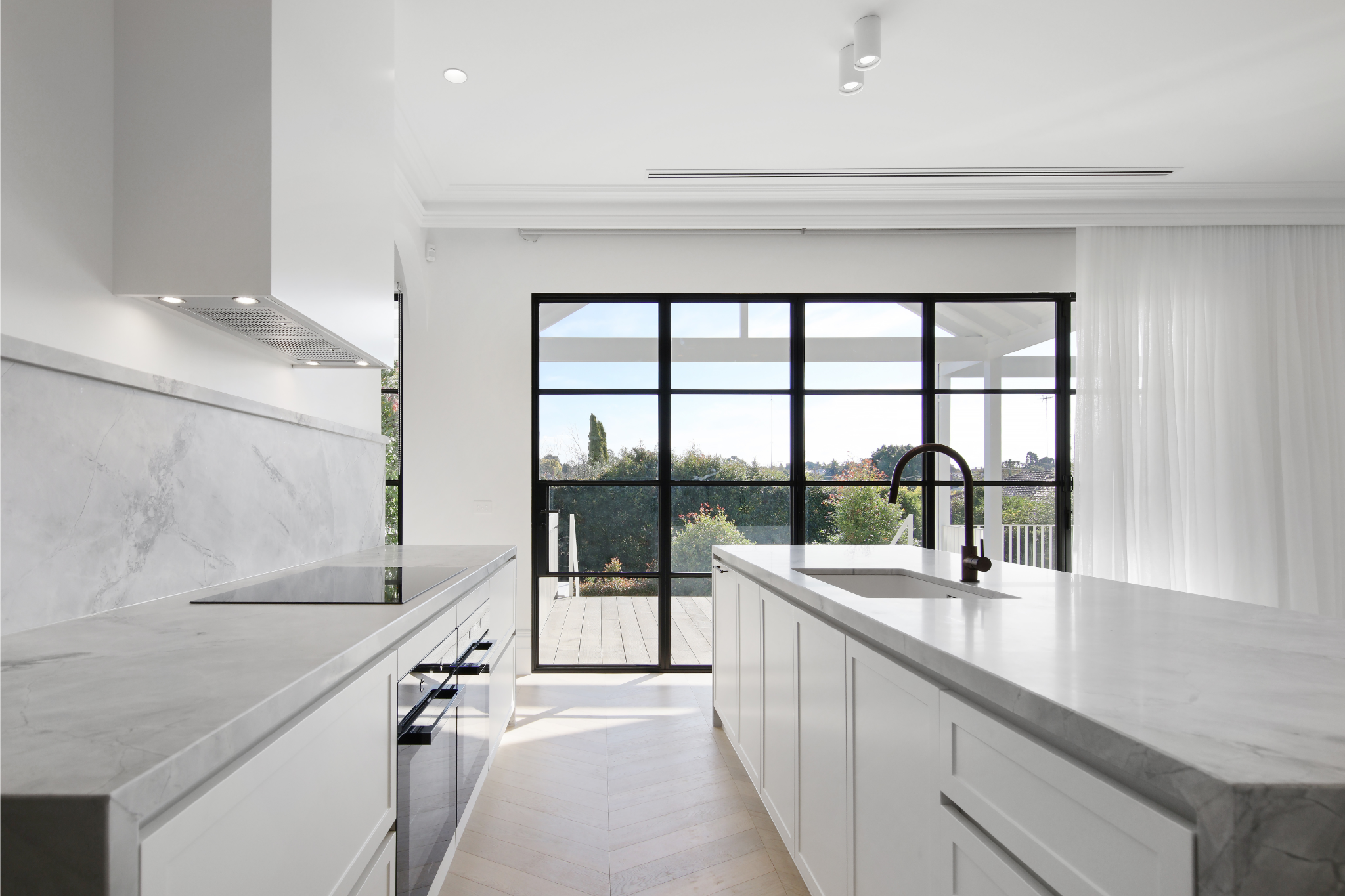 Spacious white kitchen with bespoke cabinetry.